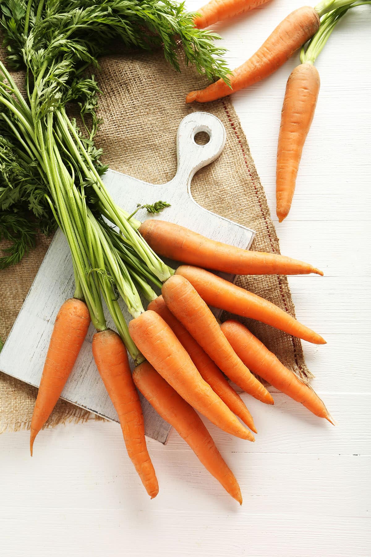 Fresh and sweet carrots on a white wooden table