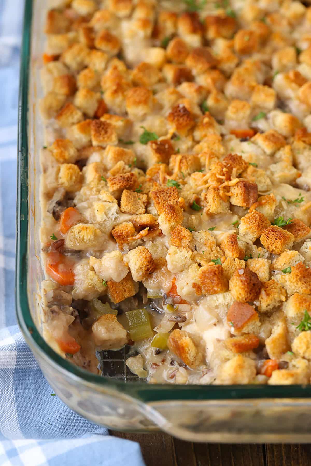 chicken and wild rice casserole in a glass baking dish with a scoop removed